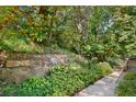 Stone tiered landscaping in backyard with garden and mature trees at 4535 Forest Green Dr, Sugar Hill, GA 30518