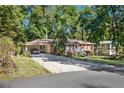 Single-story home with a covered carport, long driveway, and mature trees surrounding the property at 4535 Forest Green Dr, Sugar Hill, GA 30518