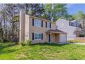 Tan two-story home with a chimney, a one-car garage, and a well-kept lawn at 2030 Hilda Burns Pl, Lithonia, GA 30058