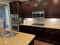 Modern kitchen with stainless steel appliances, granite countertops, and rich dark wood cabinets at 2114 Westhill Dr, Smyrna, GA 30082