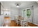 Cozy dining room boasts hardwood floors, a wood table, and natural light streaming through the window at 6909 Heritage Pl, Acworth, GA 30102