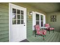 Inviting front porch featuring floral print furniture, complemented by a white door and decorative wall art at 6909 Heritage Pl, Acworth, GA 30102