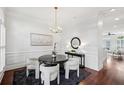 Bright dining room with a modern chandelier, wainscoting detail, and sleek black dining set and rug at 865 Inman Village Ne Pkwy, Atlanta, GA 30307