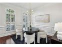 Bright dining area featuring wainscoting detail, modern chandelier, and arched window with plantation shutters at 865 Inman Village Ne Pkwy, Atlanta, GA 30307