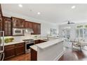 Open kitchen featuring dark wood cabinets, white countertops, and a breakfast bar overlooking the living area at 865 Inman Village Ne Pkwy, Atlanta, GA 30307