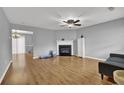 Inviting living room featuring a cozy fireplace, modern ceiling fan, and durable wood flooring at 240 Springbottom Ct, Lawrenceville, GA 30046