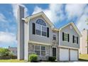 Stylish home with stone accents and a two-car garage, under a bright blue sky at 2590 Carolina Rdg, Riverdale, GA 30296