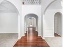 Bright foyer featuring hardwood floors, white walls, and arched doorways at 5658 Greensage Dr, Atlanta, GA 30349