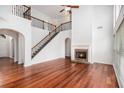 Open-concept living room featuring hardwood floors, fireplace, and a staircase at 5658 Greensage Dr, Atlanta, GA 30349