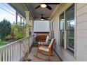 Relaxing front porch featuring comfortable seating, a swing, and ceiling fans at 93 Hammock Se Pl, Atlanta, GA 30312