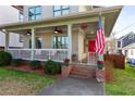 Inviting front porch with white railings, a bright red door, and lovely flower pots at 93 Hammock Se Pl, Atlanta, GA 30312