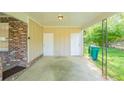 Carport area featuring brick columns, white trim, and access to storage or utility areas at 2877 Kensington Way, Rex, GA 30273