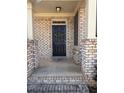 Inviting front entrance with a black door, brick surround, and decorative wreath at 404 After Glow Smt, Canton, GA 30114