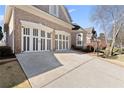 Spacious driveway leading to a two-car garage, surrounded by a beautifully maintained lawn at 5325 Davenport Mnr, Cumming, GA 30041