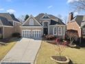 Charming brick home with a two-car garage and well-manicured landscaping, perfect for curb appeal at 5325 Davenport Mnr, Cumming, GA 30041