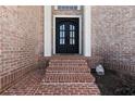 Elegant brick entryway with a classic black double door and a welcoming ambiance at 5325 Davenport Mnr, Cumming, GA 30041