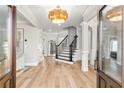 Elegant foyer with hardwood floors, decorative lighting, and a staircase at 1004 Windermere Xing, Cumming, GA 30041