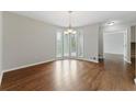 Bright dining room boasting gleaming hardwood floors and elegant chandelier lighting at 135 S Falcon Blf, Alpharetta, GA 30022