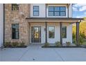 Welcoming front entrance with stone accents and a covered porch at 2875 Caney Parc Way, Cumming, GA 30041