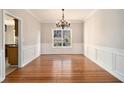 Bright dining room featuring hardwood floors, wainscoting, chair rail, and a chandelier above at 3707 Mcguire Nw St, Kennesaw, GA 30144