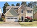 Charming two-story home features a stone accent facade, light siding, and attached garage at 3707 Mcguire Nw St, Kennesaw, GA 30144