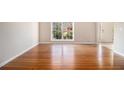 Bright, open space with hardwood floors, baseboard trim, and a large window offering a view of the outdoors at 3707 Mcguire Nw St, Kennesaw, GA 30144