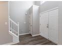 Bright foyer features wood-look flooring, white trim staircase, and multiple coat closets at 705 Brentwood Pkwy, Stockbridge, GA 30281