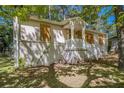 Exterior side view of single story home with white brick foundation and boarded up windows at 1907 Oak Valley Rd, Decatur, GA 30035