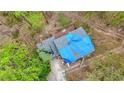 Aerial view of a damaged roof covered by blue tarps, set amidst green trees at 1340 Nerine Cir, Atlanta, GA 30338