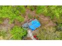 Aerial view of home with blue tarp covered roof, showing deck and surrounding trees at 1340 Nerine Cir, Atlanta, GA 30338