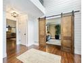 Foyer featuring shiplap walls, a jute rug, and sliding barn doors to the office at 3965 Hamilton View Way, Dacula, GA 30019