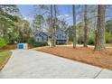 Exterior shot of a blue two-story home with long driveway, mature trees, and a well-kept lawn at 7660 Brentwood Ct, Cumming, GA 30040