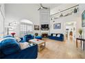 Bright living room with vaulted ceiling, fireplace, large windows, and stylish blue furniture at 3800 Lake Pass Ln, Suwanee, GA 30024