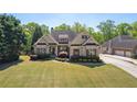Charming brick home featuring manicured landscaping and attached garage at 5055 Stefan Ridge Way, Buford, GA 30519
