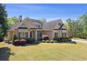 Beautiful brick home with meticulously maintained landscaping and a three-car garage at 5055 Stefan Ridge Way, Buford, GA 30519