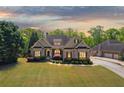 Inviting single-Gathering home with manicured lawn, beautiful landscaping, and a separate three-car garage at 5055 Stefan Ridge Way, Buford, GA 30519