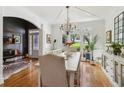 Bright dining room featuring hardwood floors, chandelier lighting, and large windows with backyard views at 2305 Stonevalley Ct, Cumming, GA 30041