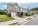 Exterior view of a townhome with a one-car garage and well-maintained landscaping at 2051 Wildflower Way, Conyers, GA 30012