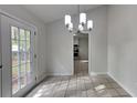 Bright dining area featuring modern chandelier and door leading to the outdoors at 4111 Sweet Water Ct, Conyers, GA 30094