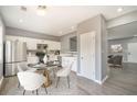 Bright kitchen features white cabinetry, stainless steel appliances and adjacent dining area at 74 Venture Path, Hiram, GA 30141
