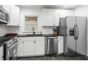Modern kitchen featuring white cabinets, granite countertops and stainless steel appliances at 1386 Sandy Ln, Decatur, GA 30032