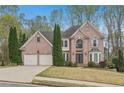 Attractive two-story brick home with a well-kept lawn and a convenient two-car garage at 3887 Hickory Manor Dr, Suwanee, GA 30024