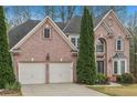 Lovely brick home featuring a two-car garage and mature landscaping, set in a peaceful neighborhood at 3887 Hickory Manor Dr, Suwanee, GA 30024