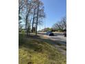 Street view with blue truck driving on the road and green space on the shoulder at 3674 Canton Rd, Marietta, GA 30066