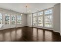 Bright living room featuring hardwood floors, modern lighting, and large windows at 6812 Cadence Blvd, Atlanta, GA 30328