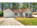 Inviting home with a driveway, lush lawn, and charming curb appeal at 10331 Wrens Dr, Jonesboro, GA 30238