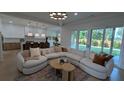 Open-concept living room with a comfortable sectional sofa, modern lighting, and access to the backyard at 315 Hillcrest View Dr, Suwanee, GA 30024