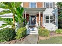 Close-up of home's entry, showcasing covered porch, gray front door, and landscaped front yard at 4551-0 Howell Farms Nw Rd, Acworth, GA 30101
