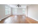 Bright living room with hardwood floors, ceiling fan, and large windows, filling the space with natural light at 4915 Wycliffe Dr, Stone Mountain, GA 30087