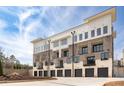 Exterior view of the townhomes, showcasing balconies and attached garages at 7210 Summit Pl, Alpharetta, GA 30009